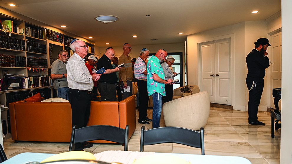 Men standing together in song at Rabbi Vigler’s home farbrengen