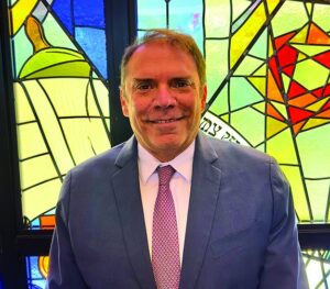 Rabbi Fabian Werbin before a stained glass window at Temple Emanu-El