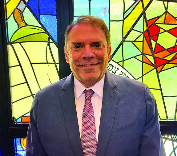 Rabbi Fabian Werbin before a stained glass window at Temple Emanu-El